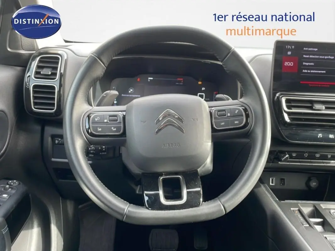 Vue intérieure centrée sur le volant cuir multifonctions et le cockpit numérique du Citroën C5 Aircross 2024.
