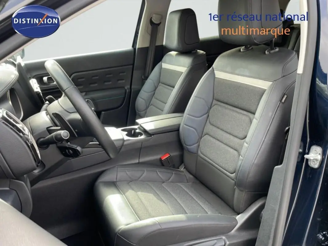 Vue intérieure côté conducteur du Citroën C5 Aircross bleu 2024, sièges en cuir et tissu gris avec volant multifonctions.