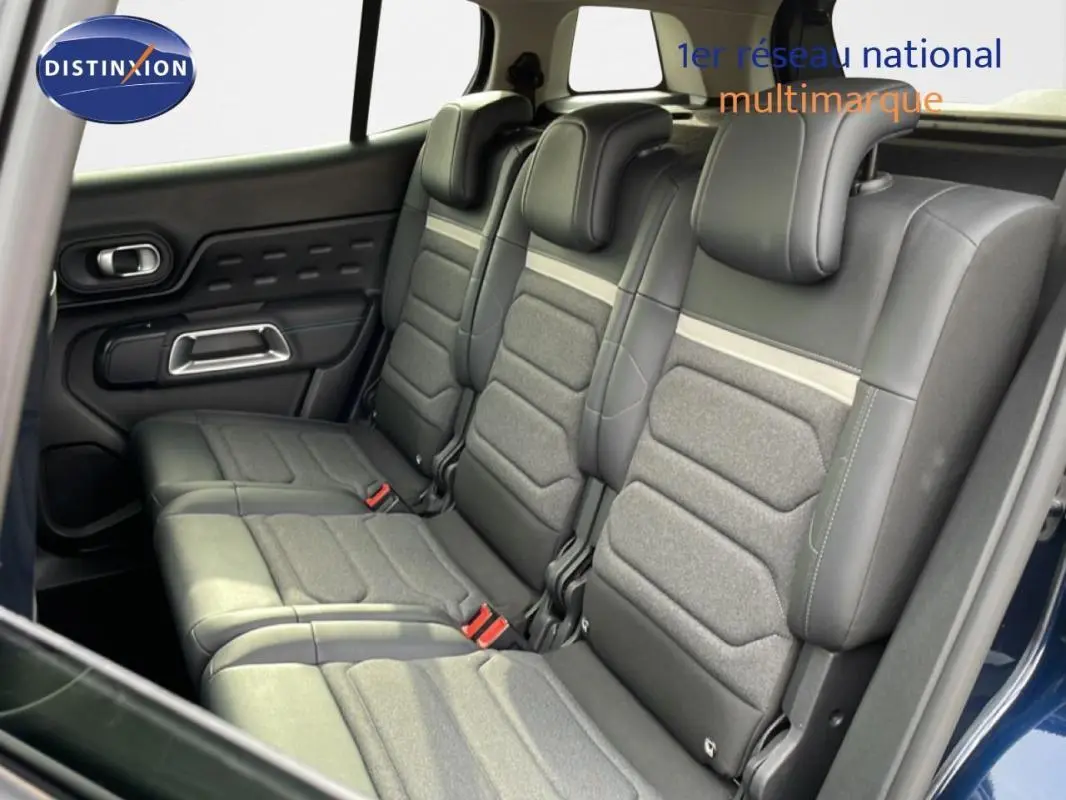 Vue intérieure côté gauche montrant les sièges arrière en tissu et cuir gris du Citroën C5 Aircross bleu 2024.