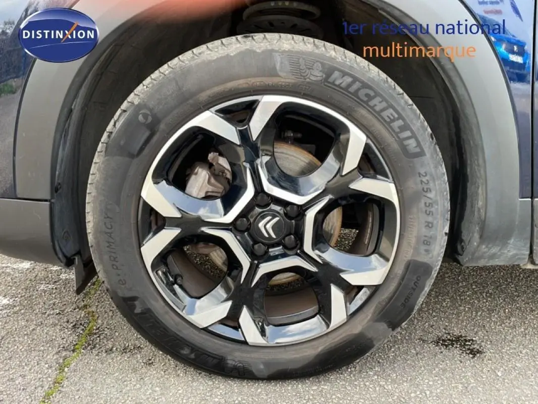 Gros plan sur la jante aluminium noire et argentée du côté avant gauche d’un Citroën C5 Aircross bleu 2024.