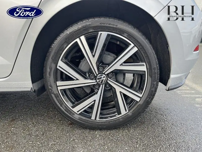 Gros plan sur la roue avant droite d'une Volkswagen Polo 1.0 TSI R-Line argent métallisé avec jante alu noire et argent.