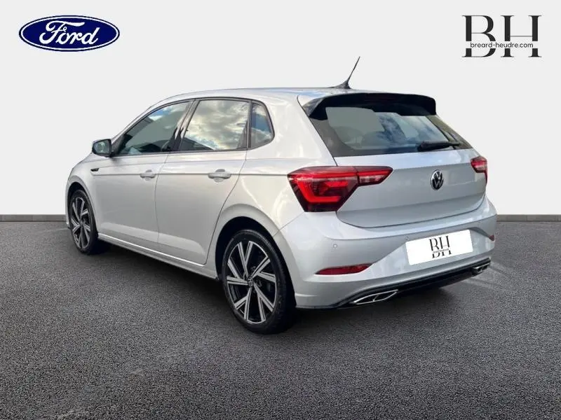 Volkswagen Polo 1.0 TSI R-Line en Reflet d'Argent métallisé, vue 3/4 arrière côté gauche avec jantes alu distinctives.