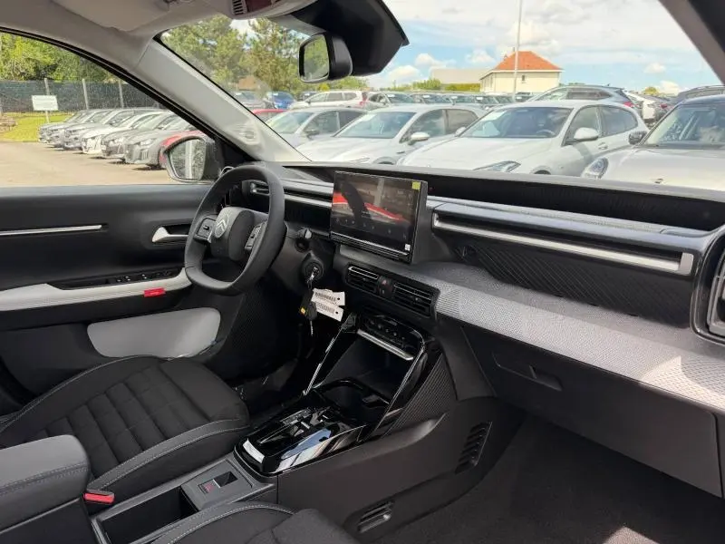 Vue intérieure côté conducteur de la Citroën C3 Aircross 2026 avec tableau de bord noir et écran tactile central.