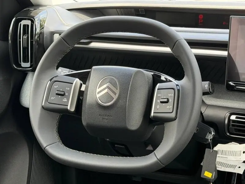 Vue rapprochée du volant multifonction noir de la Citroën C3 Aircross 2026 avec logo argenté au centre.