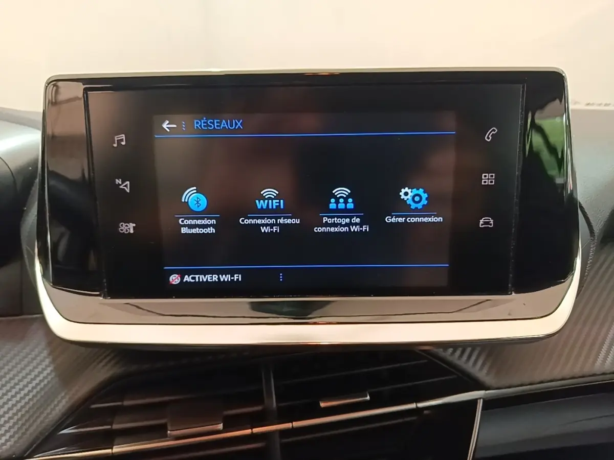 Écran tactile central de la Peugeot 208 PureTech 100 S&S Active Pack 2023 affichant les options de connexion Wi-Fi et Bluetooth.