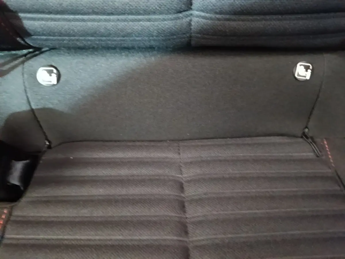 Gros plan sur la banquette arrière noire du Peugeot 208 2023, montrant les fixations Isofix de chaque côté.