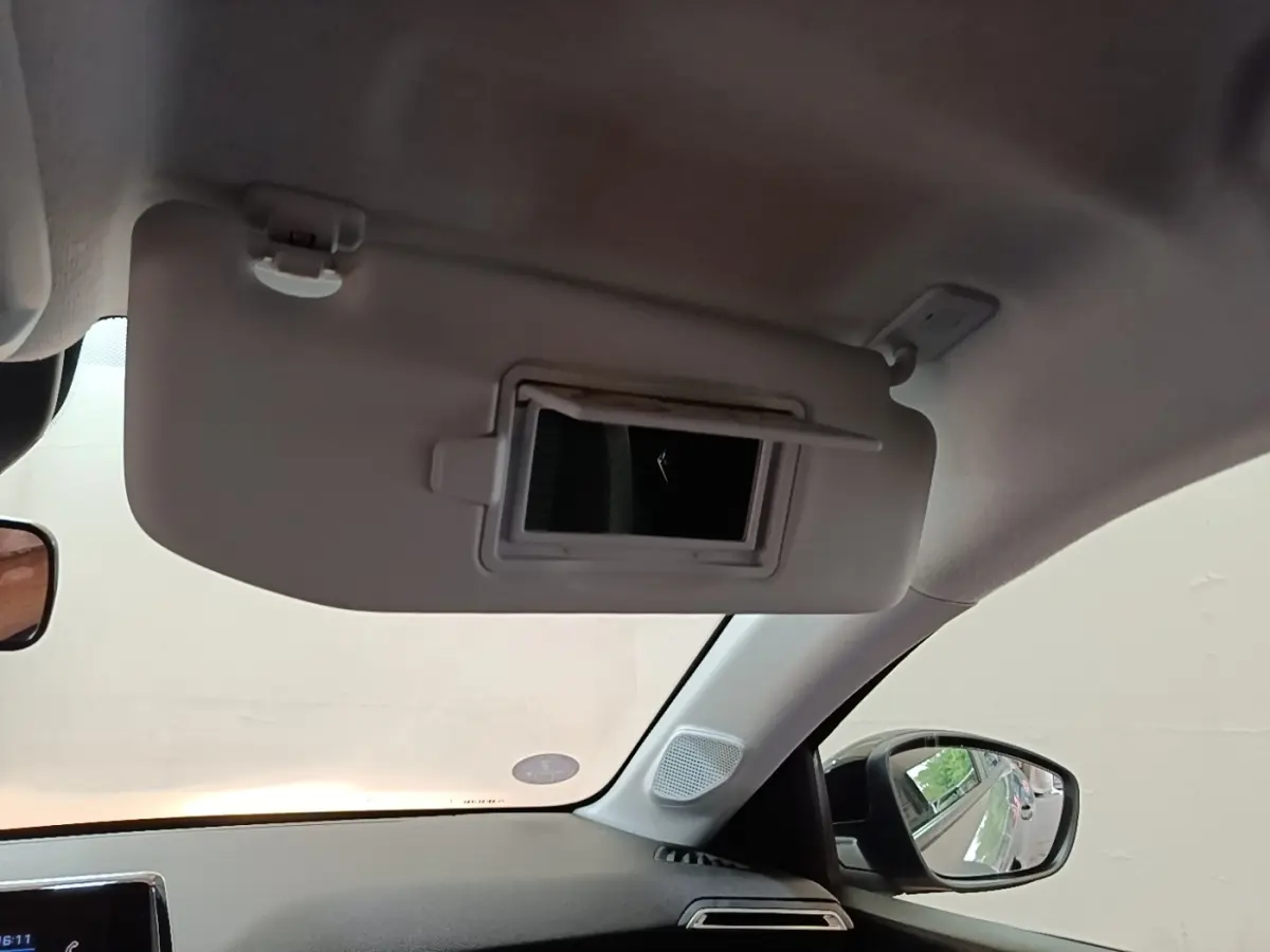 Détail du pare-soleil côté conducteur avec miroir intégré dans l'habitacle d'une Peugeot 208 gris clair.