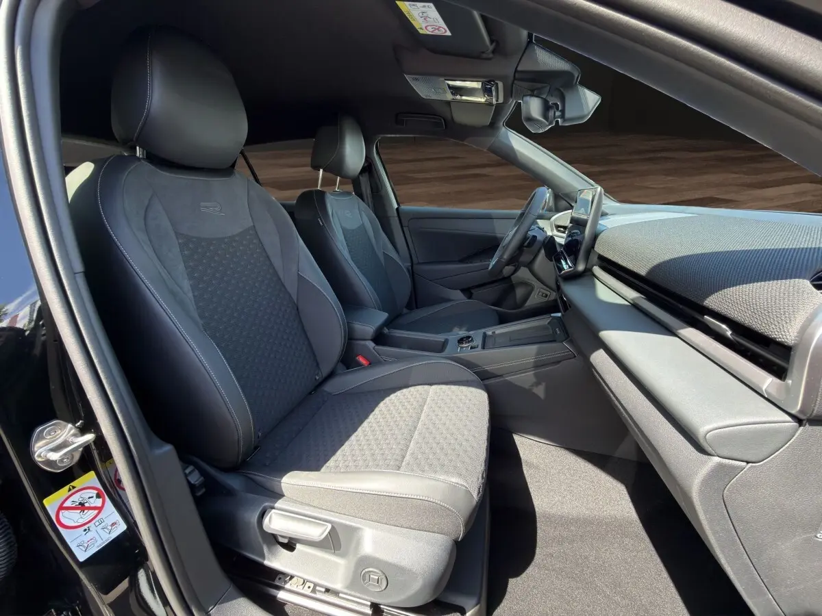 Vue intérieure côté conducteur du Volkswagen T-Roc noir 2026, mettant en valeur les sièges R-Line et le tableau de bord moderne.