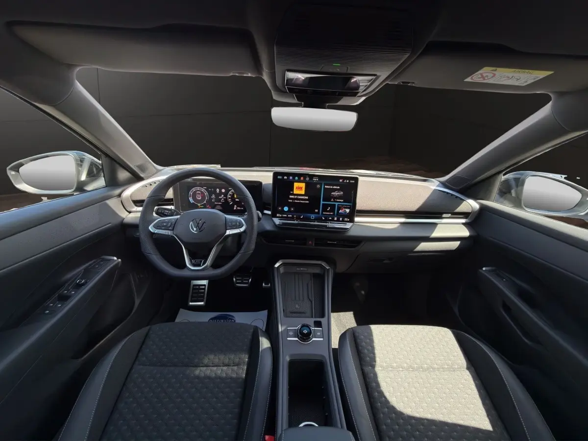 Vue intérieure avant du Volkswagen T-Roc noir 2026, avec tableau de bord numérique et écran tactile central.
