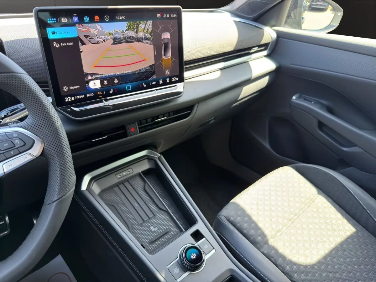 Vue intérieure côté passager du Volkswagen T-Roc noir 2026, avec écran tactile affichant l'aide au stationnement.