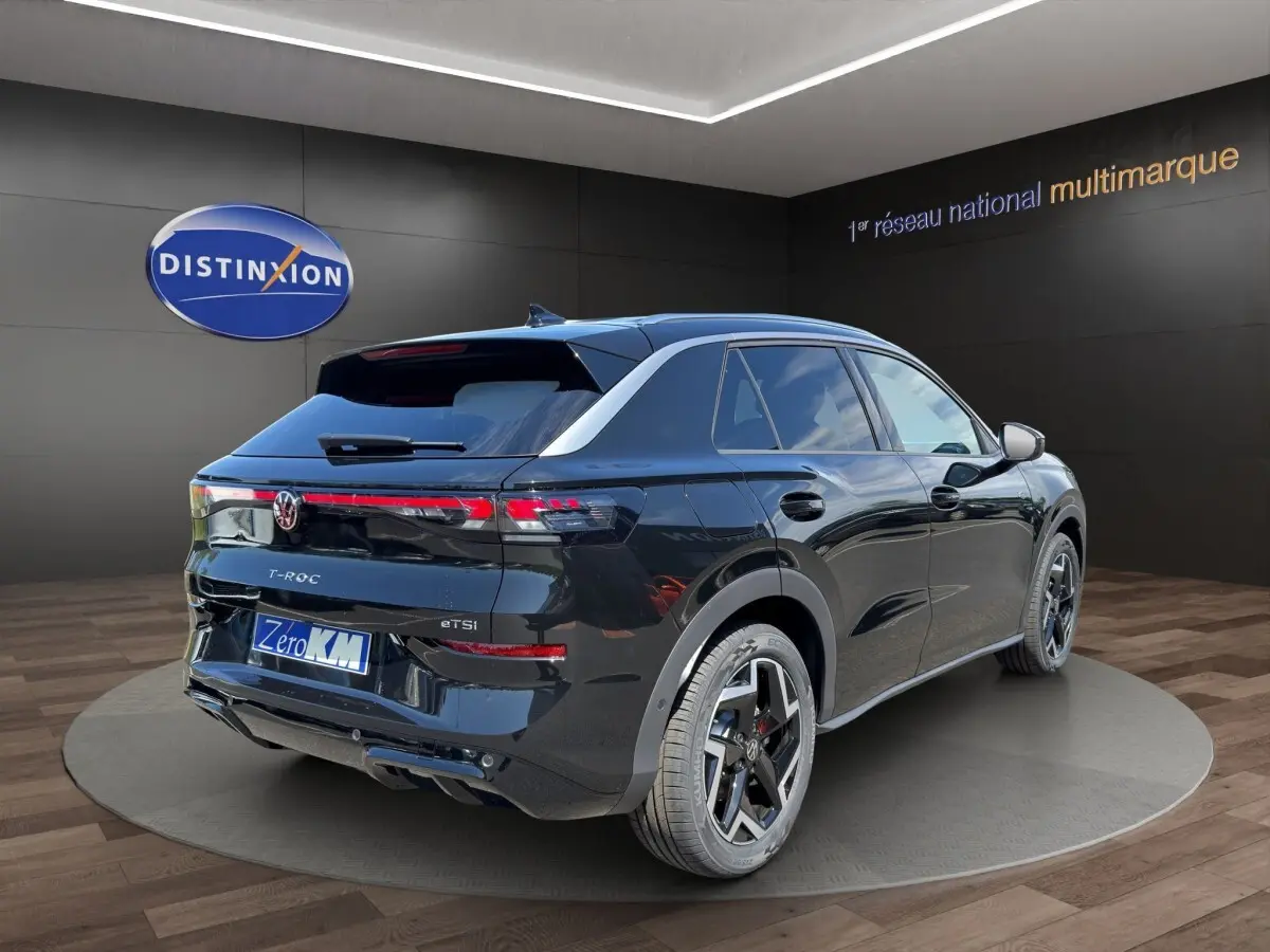 Volkswagen T-Roc noir vue 3/4 arrière droit, avec feux arrière LED et jantes alliage distinctives.
