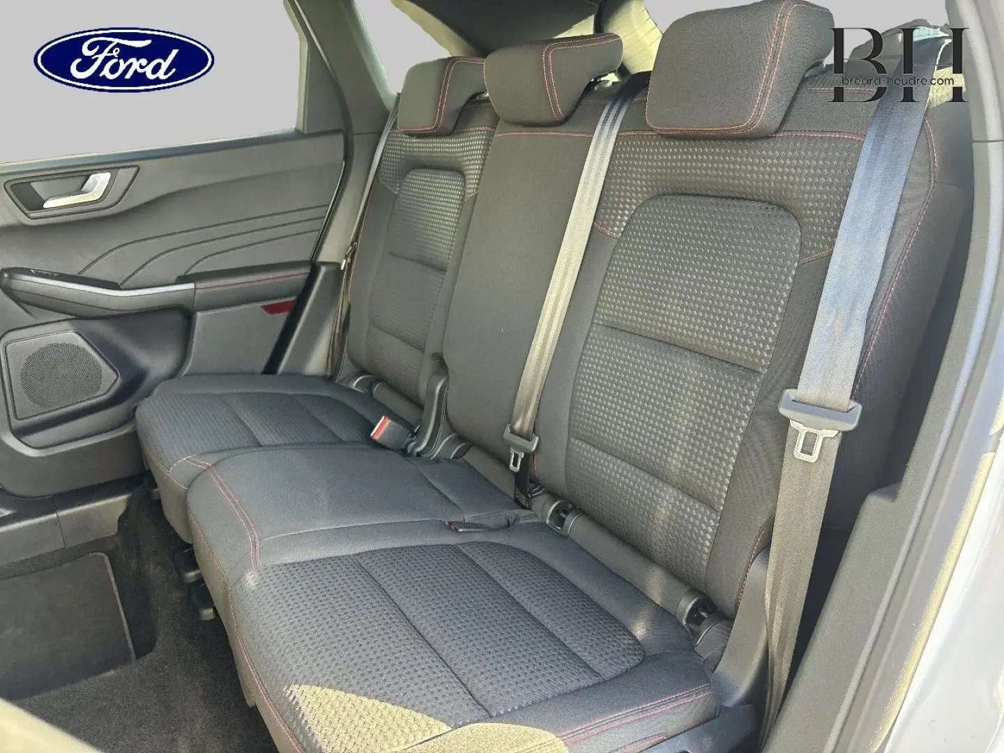 Vue latérale gauche de la banquette arrière noire avec surpiqûres rouges du Ford Kuga blanc Platinum 2021.