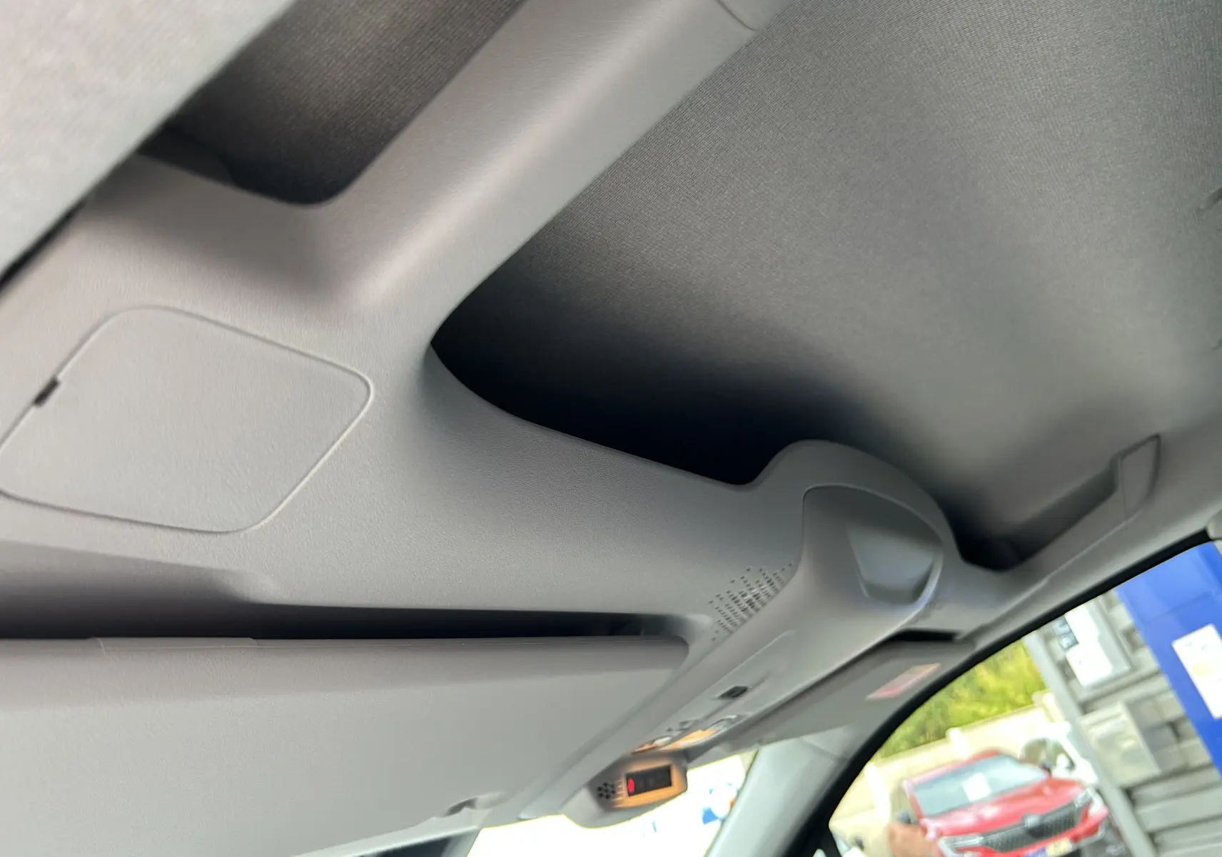 Vue intérieure du plafond et pare-soleil côté conducteur du Peugeot Partner Fourgon blanc, avec lumière et capteurs intégrés.