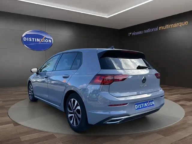 Volkswagen Golf VIII gris lunaire vue 3/4 arrière droit avec toit panoramique et jantes alu 16 pouces.