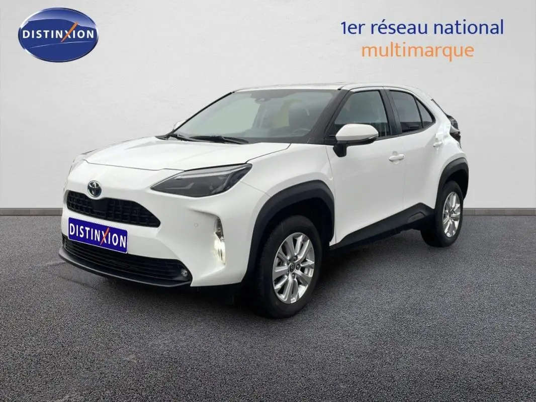 Toyota Yaris Cross Hybrid blanc vue 3/4 avant droit avec jantes aluminium et protections noires contrastées.