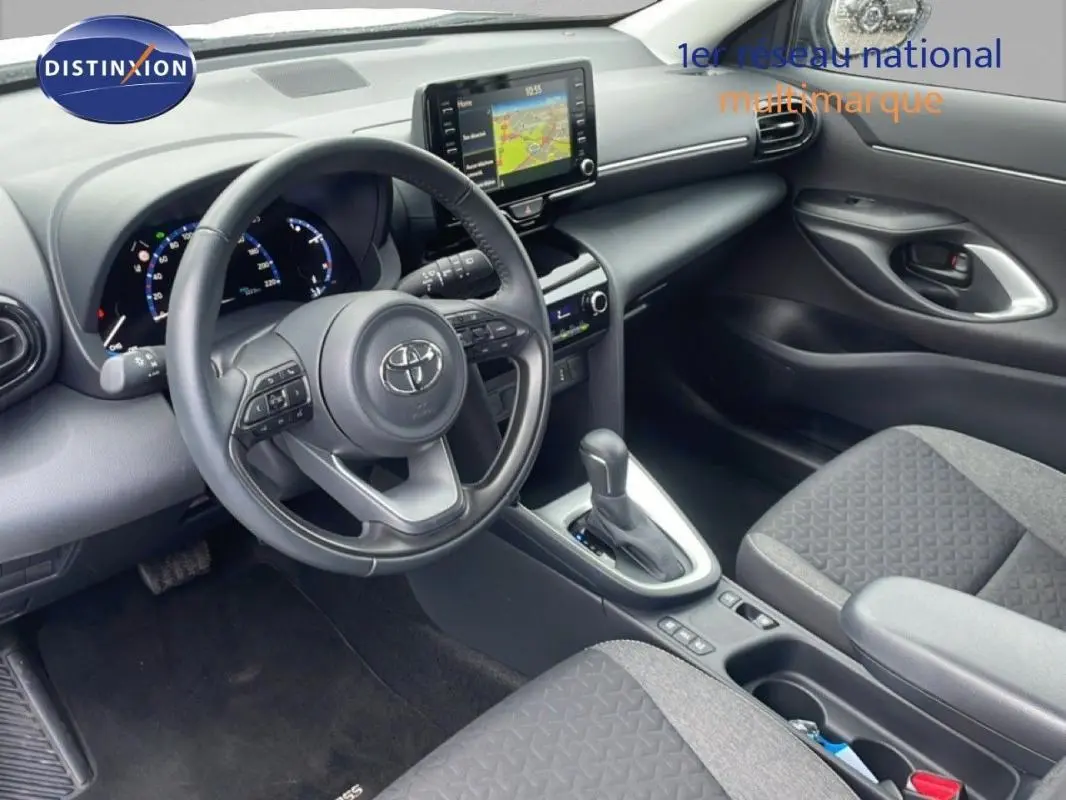Vue intérieure côté conducteur de la Toyota Yaris Cross Hybrid 2024, volant cuir avec commandes et écran tactile GPS.