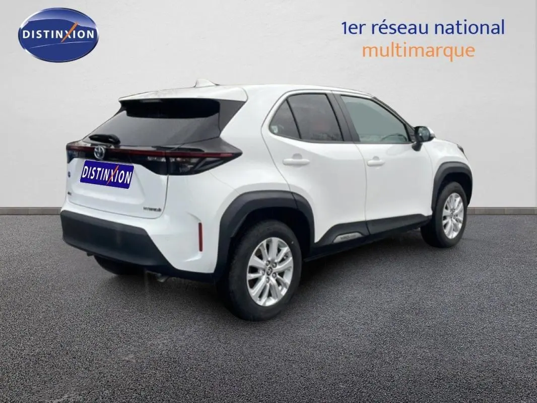 Vue 3/4 arrière droite d'une Toyota Yaris Cross Hybrid blanche avec jantes aluminium et toit noir contrasté.