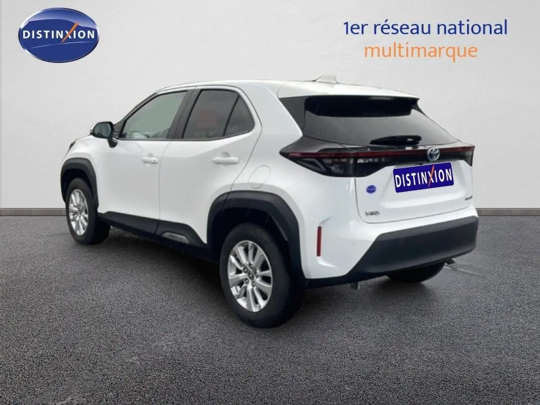 Vue 3/4 arrière droite d'une Toyota Yaris Cross Hybrid blanche de 2024 avec jantes aluminium et vitres teintées.