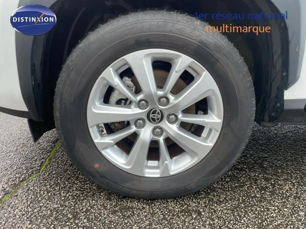 Gros plan sur la jante aluminium 16 pouces et le pneu du côté avant droit de la Toyota Yaris Cross blanche 2024.