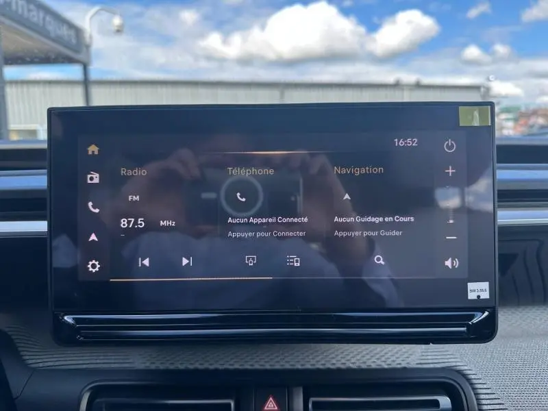 Écran tactile central du tableau de bord du Citroën C3 Aircross gris Mercury, affichant radio et navigation.