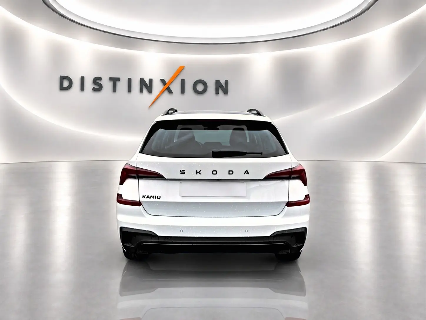 Vue arrière d'un Skoda Kamiq blanc nacré dans un showroom lumineux avec logo Distinxion en arrière-plan.