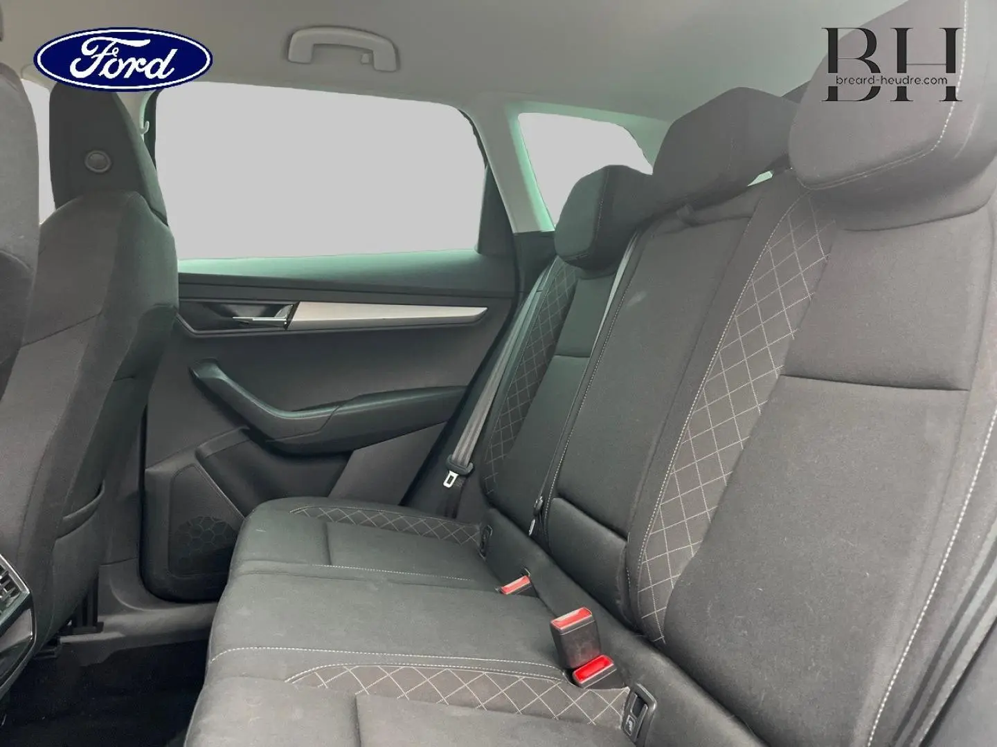 Vue intérieure de la banquette arrière en tissu gris avec motifs losanges du Skoda Karoq, côté droit visible.