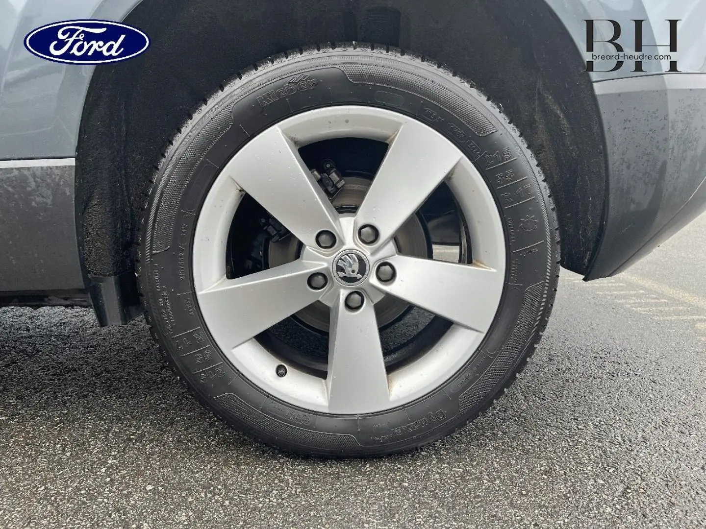 Gros plan sur la roue avant gauche d'un Skoda Karoq gris Business avec jante alliage cinq branches.