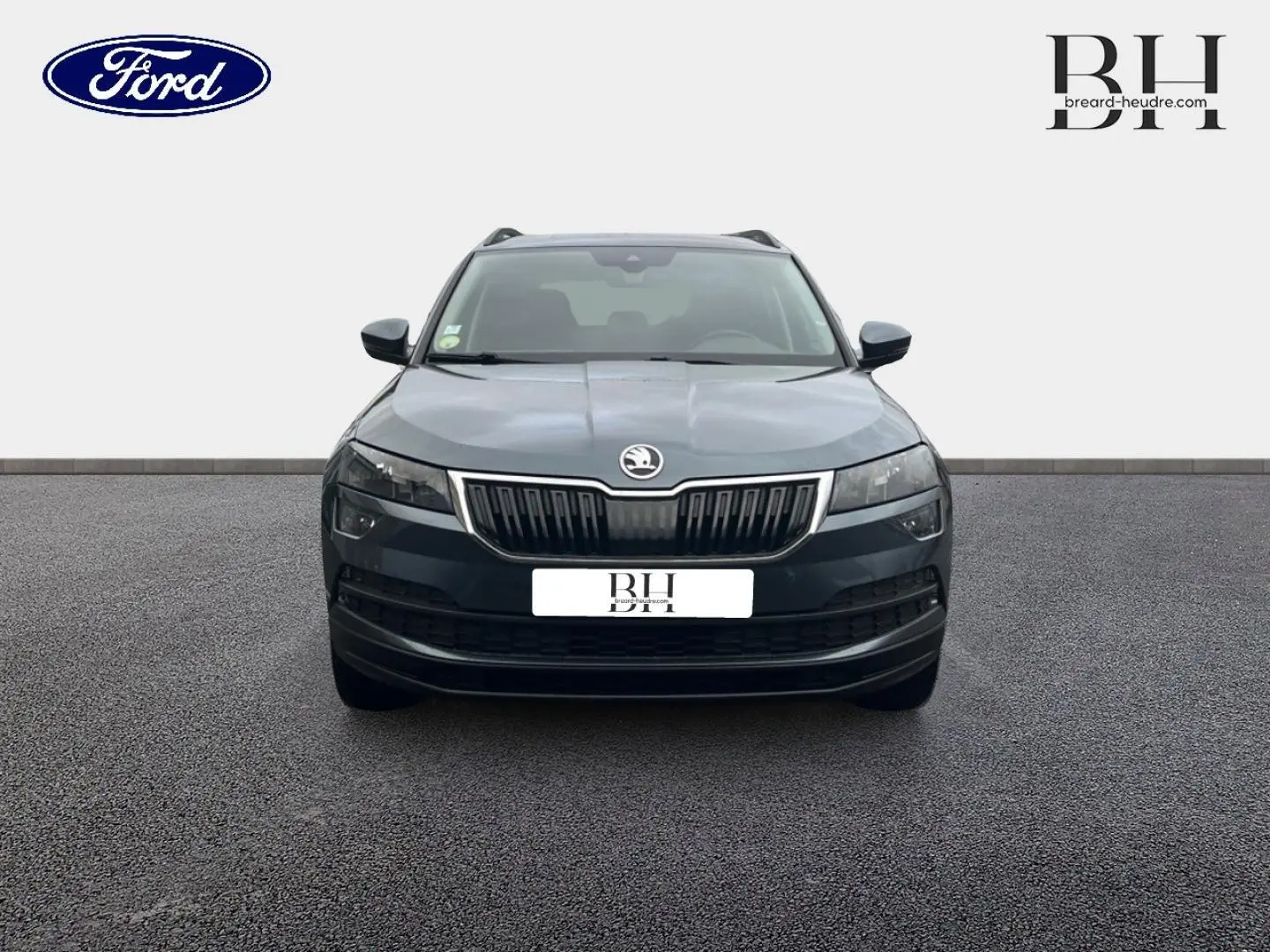 Vue avant d'un Skoda Karoq gris Business 2020 avec calandre chromée et phares LED distinctifs.