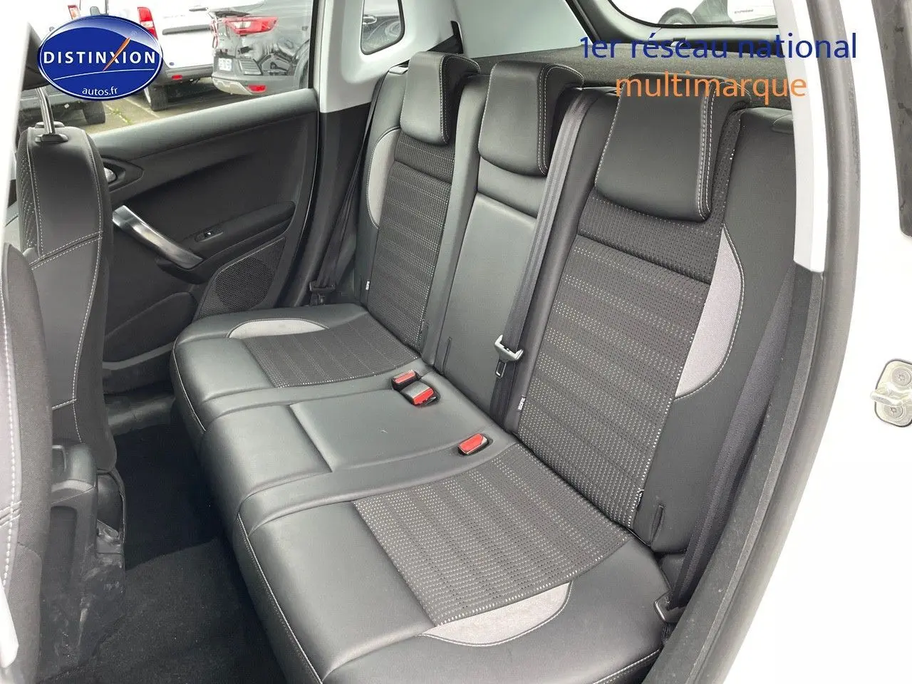 Vue intérieure arrière côté droit du Peugeot 2008 blanc nacré, montrant les sièges en cuir noir avec surpiqûres grises.