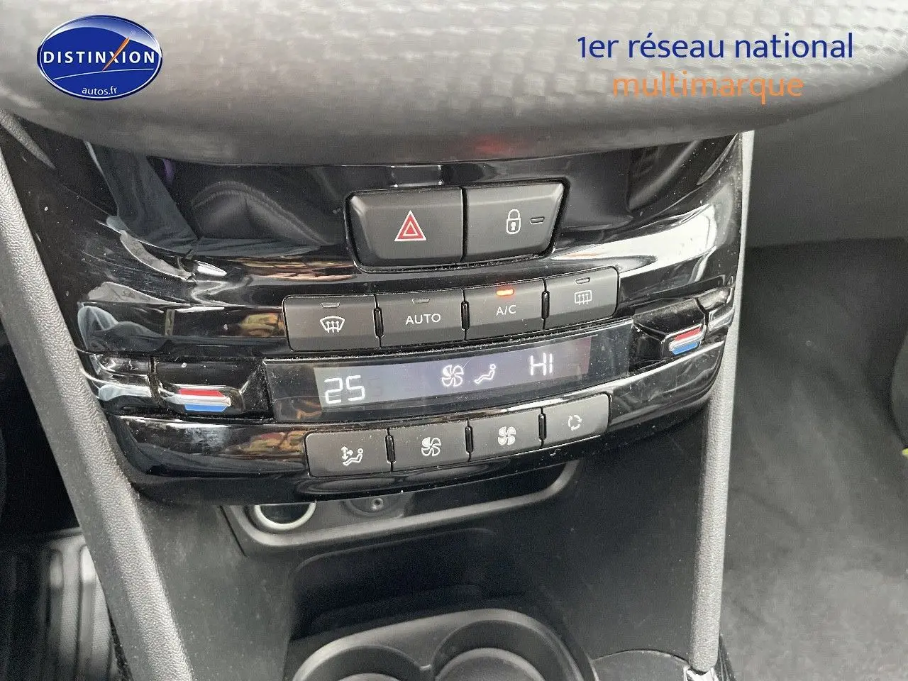 Gros plan sur la console centrale noire brillante de la Peugeot 2008 blanche, affichant la climatisation automatique à 25°C.