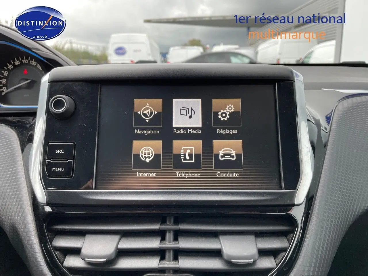 Écran tactile central du tableau de bord du Peugeot 2008 blanc nacré, affichant les menus navigation et média.