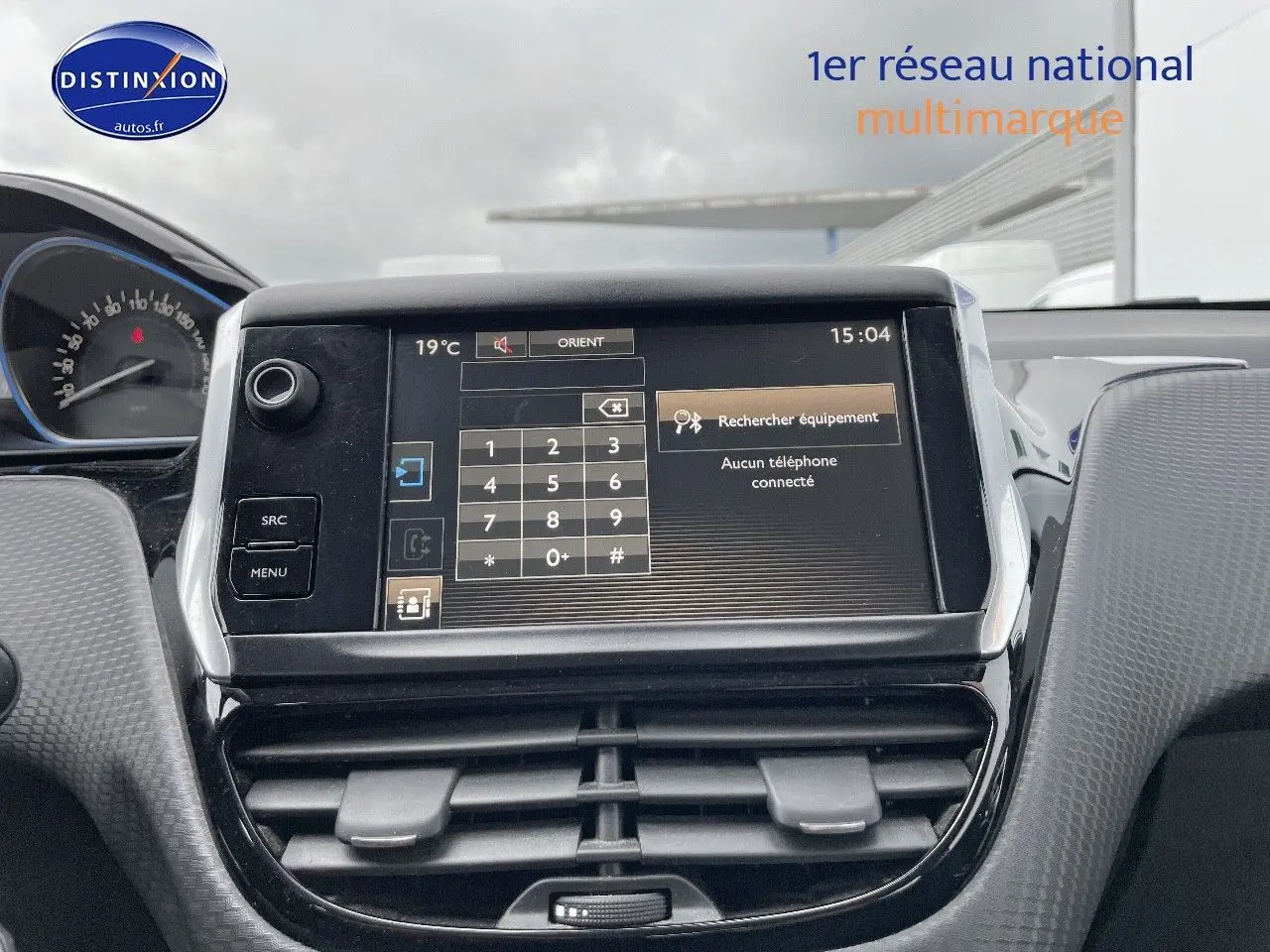 Écran tactile central du tableau de bord de la Peugeot 2008 blanc nacré, avec commandes et affichage du téléphone.