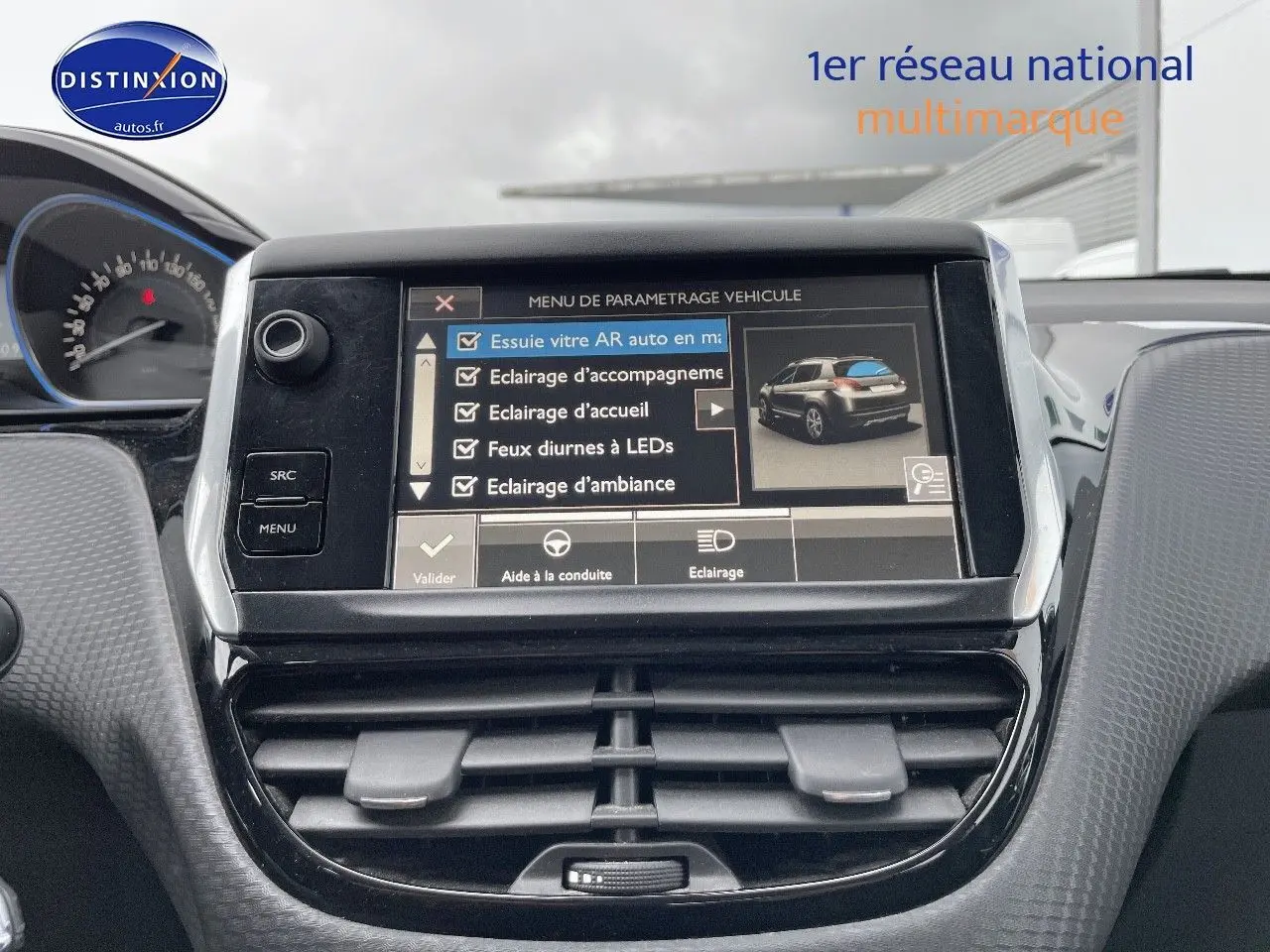 Vue rapprochée de l'écran tactile central du tableau de bord du Peugeot 2008 blanc nacré, affichant le menu de paramétrage véhicule.