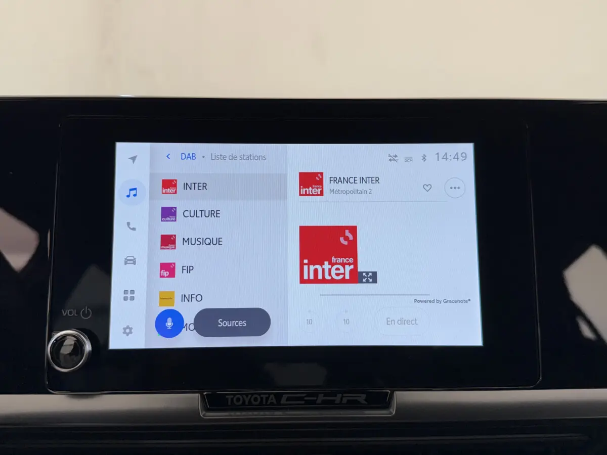 Écran tactile central du Toyota C-HR 1.8 Hybride blanc, affichant la radio France Inter en mode DAB.