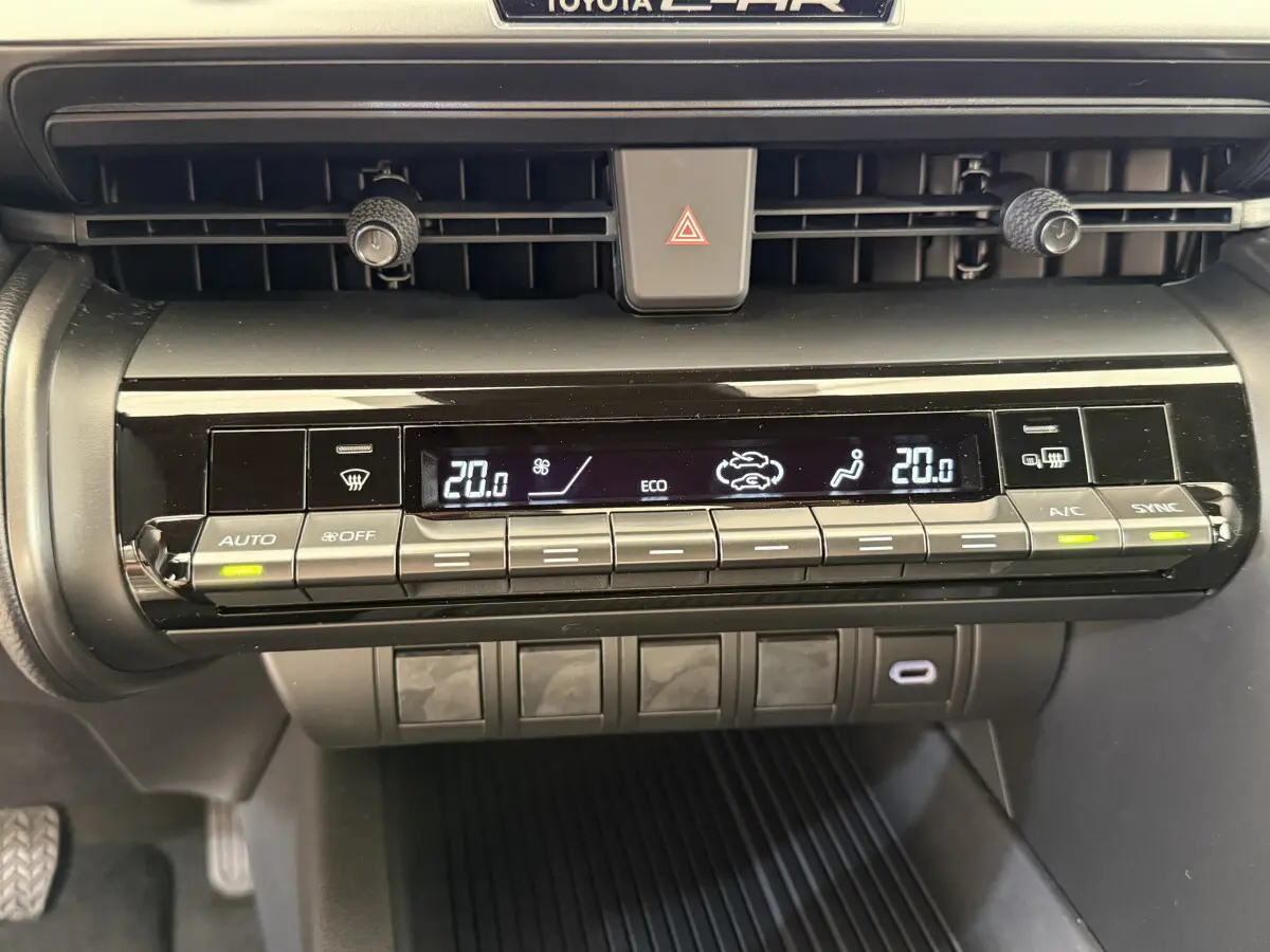 Panneau de commande de climatisation digitale du Toyota C-HR 1.8 Hybride blanc, affichage température à 20°C.