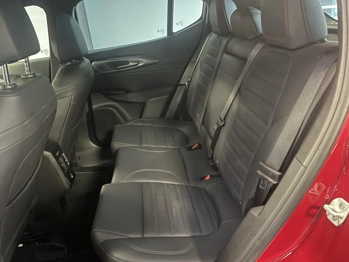 Vue intérieure côté droit des sièges arrière en cuir noir de l'Alfa Romeo Tonale rouge avec ceinture de sécurité et accoudoir central.