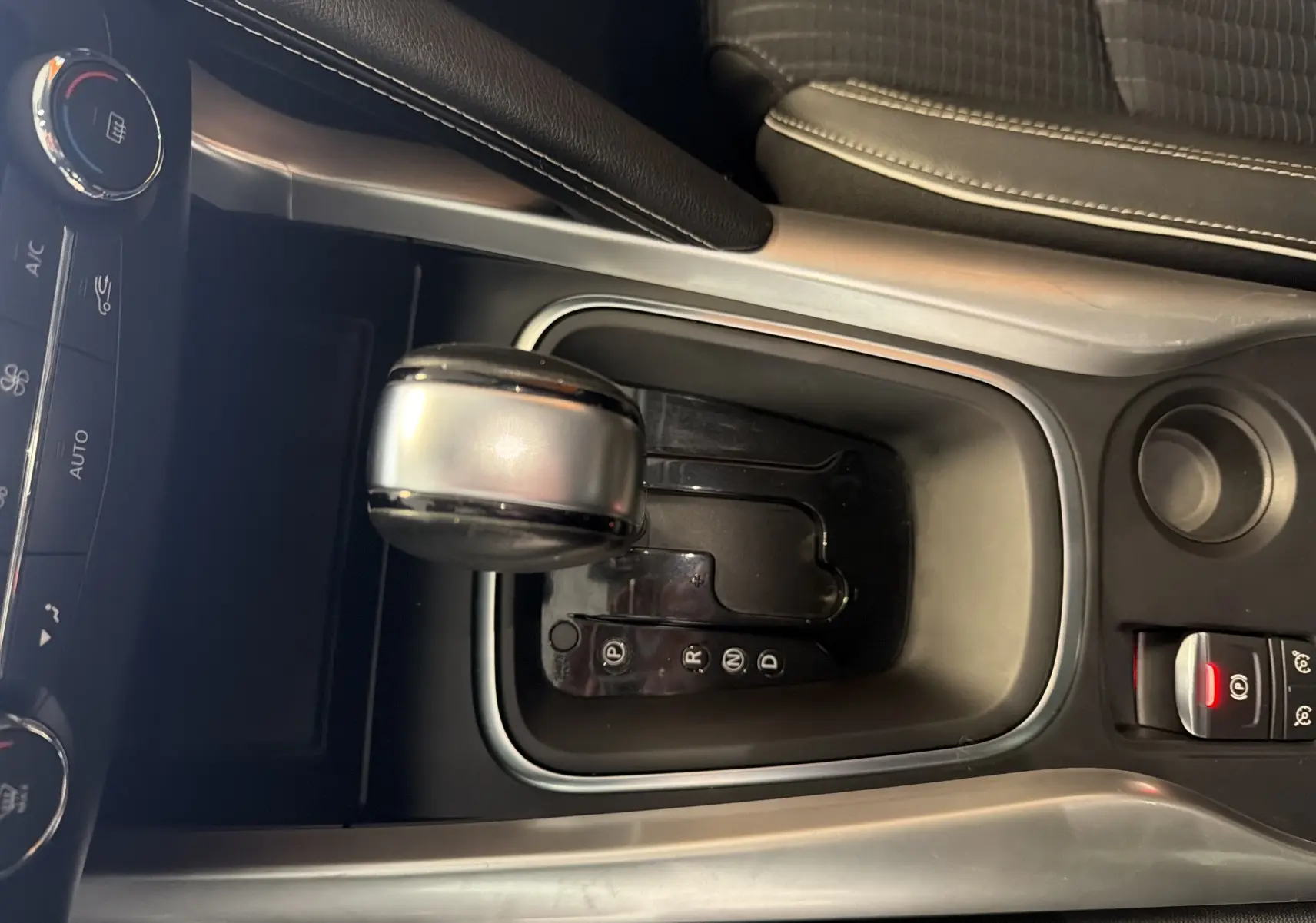 Vue rapprochée du levier de vitesses automatique gris et noir du Renault Kadjar 2016, avec frein à main électronique.