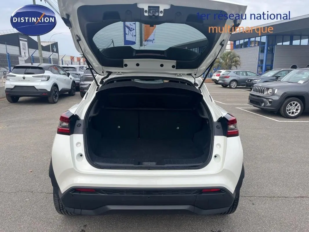 Vue arrière d'un Nissan Juke blanc 2024 avec coffre ouvert, mettant en valeur son espace de chargement.