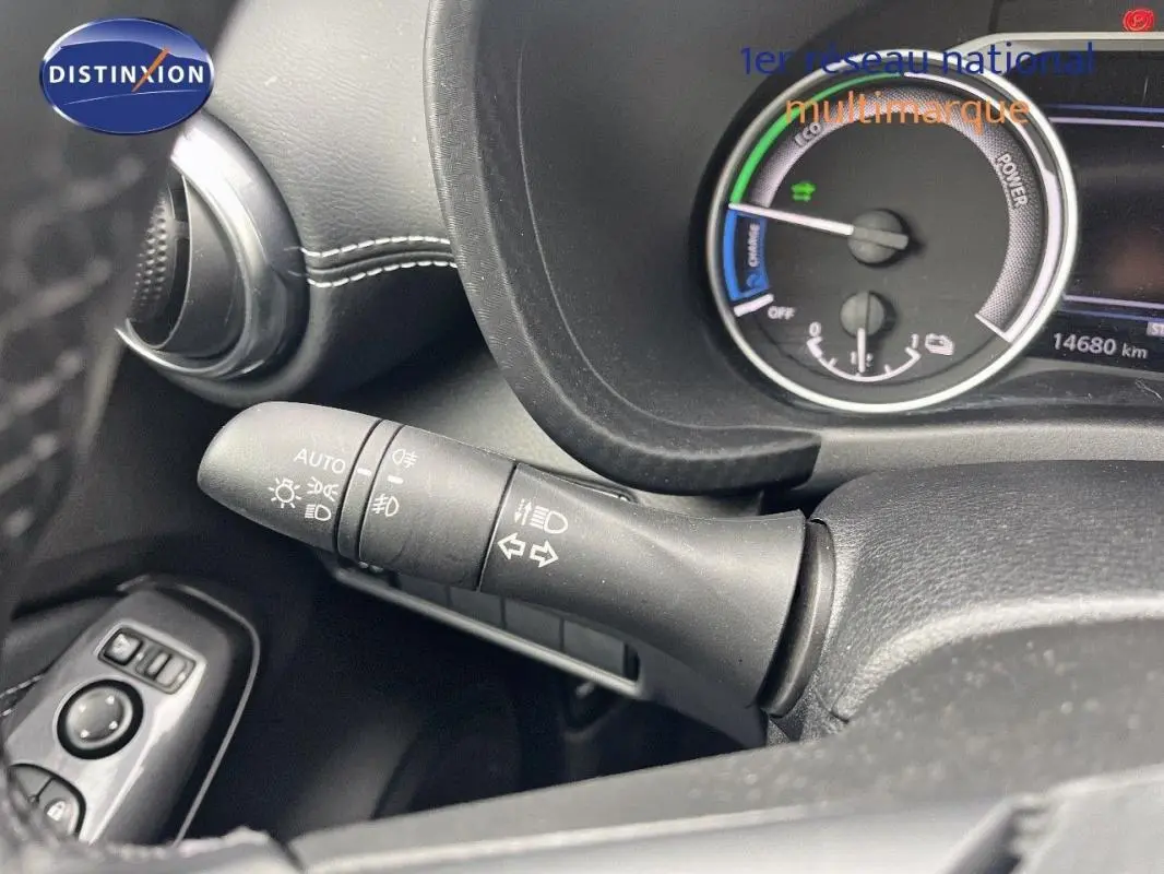 Gros plan sur la commande des feux et clignotants à gauche du volant dans un Nissan Juke blanc 2024 hybride.