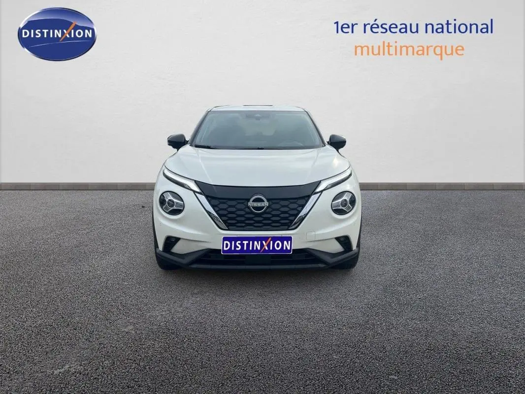 Vue de face du Nissan Juke blanc 2024 avec calandre noire et phares ronds distinctifs sur fond neutre.