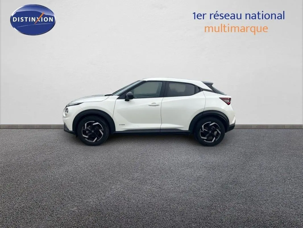 Profil droit d'un Nissan Juke blanc 2024 avec jantes aluminium et rétroviseurs noirs contrastants.