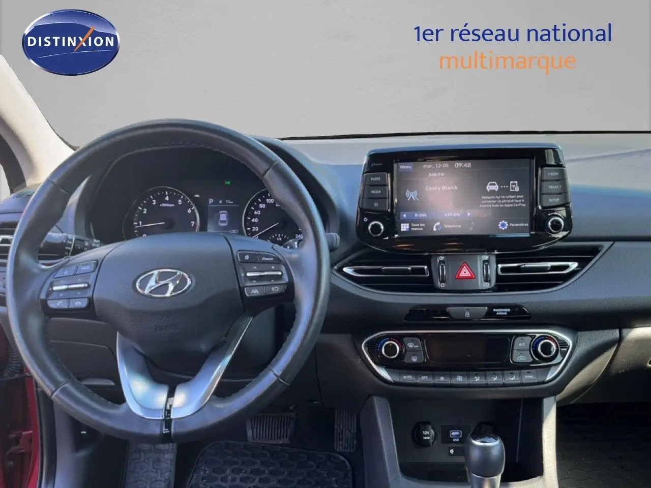 Vue intérieure du tableau de bord de la Hyundai i30 SW 2023, avec volant multifonction et écran tactile central.