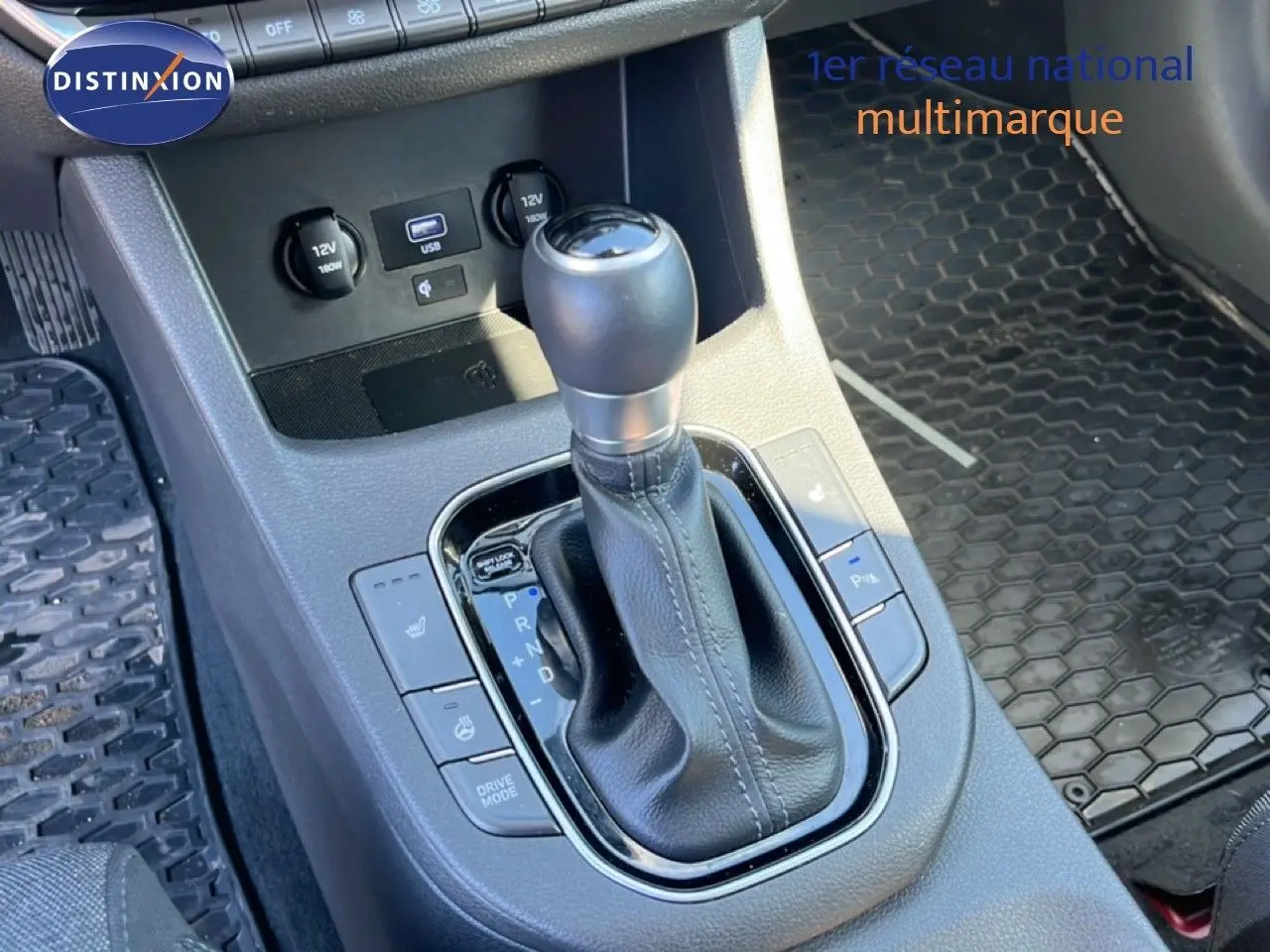 Gros plan sur la console centrale de la Hyundai i30 SW 2023, montrant le levier de vitesse automatique et les commandes de confort.