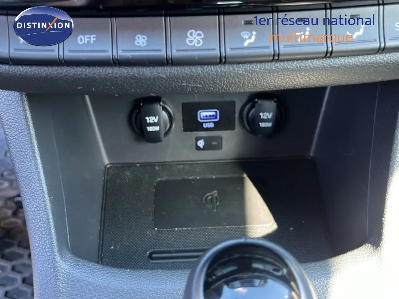 Gros plan sur la console centrale de la Hyundai i30 SW 2023, montrant prises 12V, port USB et commandes climatisation.