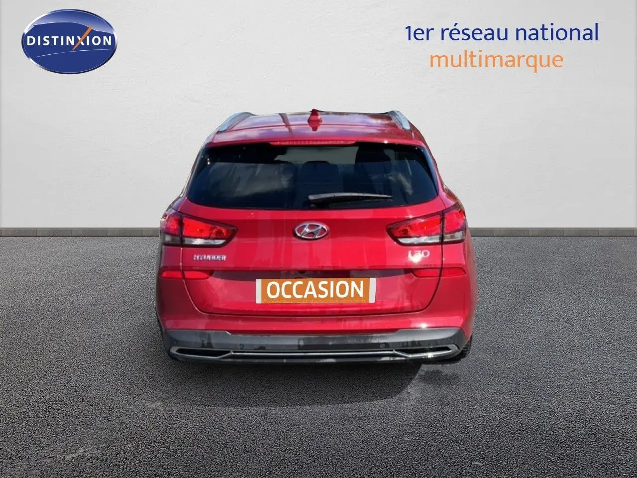 Vue arrière d'une Hyundai i30 SW 2023 rouge Sunset Red Metal avec feux LED et badge i30 visible.