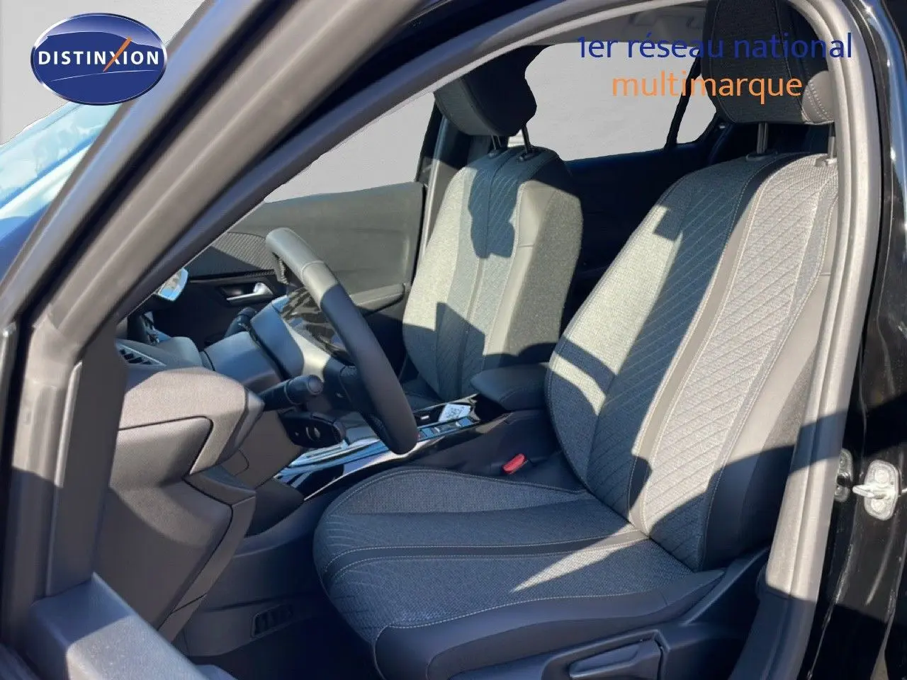 Vue intérieure côté gauche du Peugeot 208 Hybrid 110ch Allure 2026 noir perla metal, sièges tissu et cuir gris avec surpiqûres.
