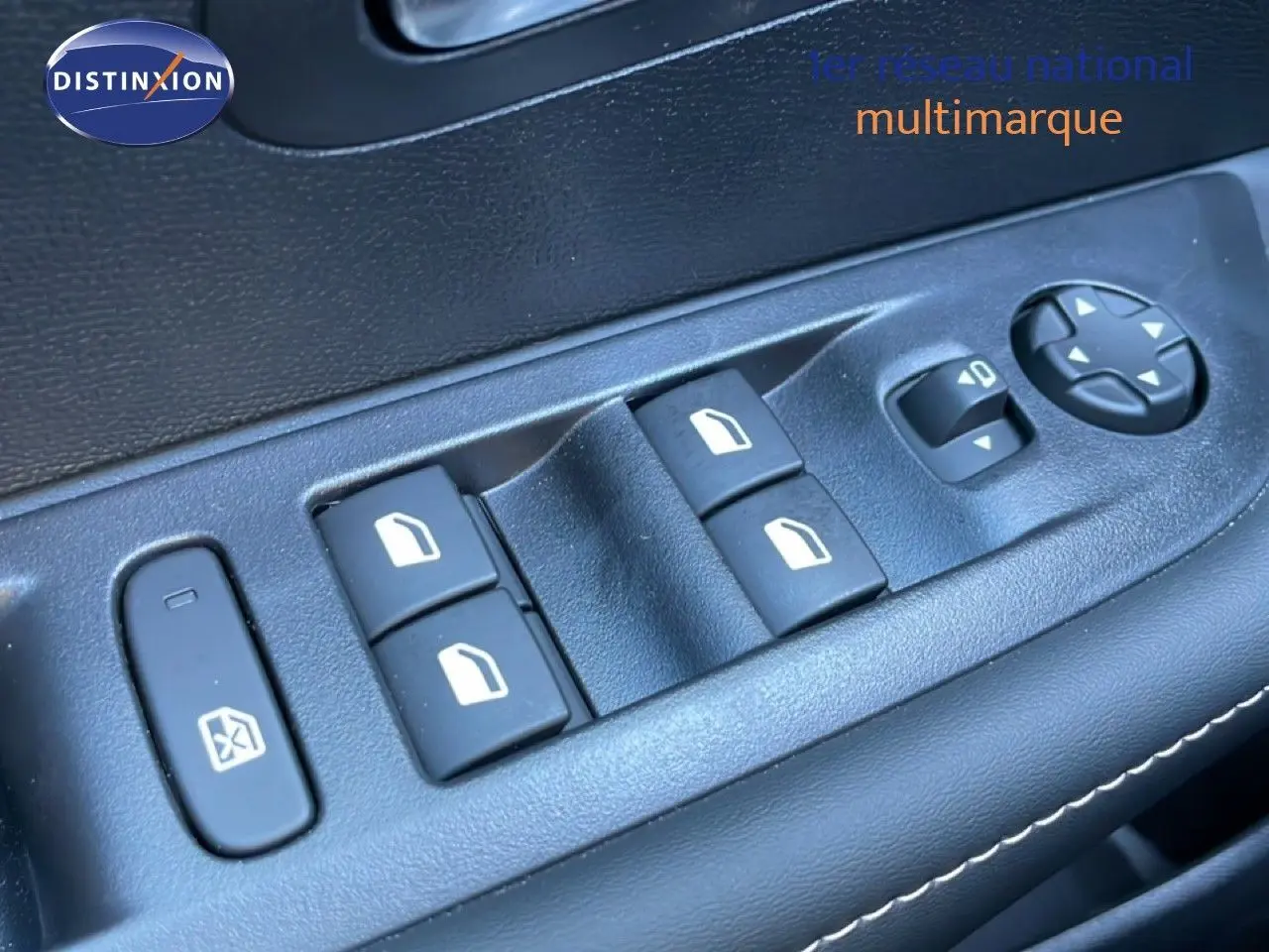 Gros plan sur les commandes de lève-vitres et rétroviseurs côté gauche intérieur d'une Peugeot 208 noire.