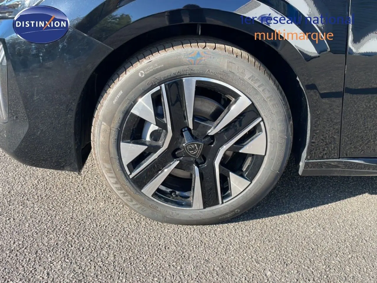 Gros plan sur la roue avant droite noire et argentée d'une Peugeot 208 Hybrid 110ch Allure noir Perla Metal.
