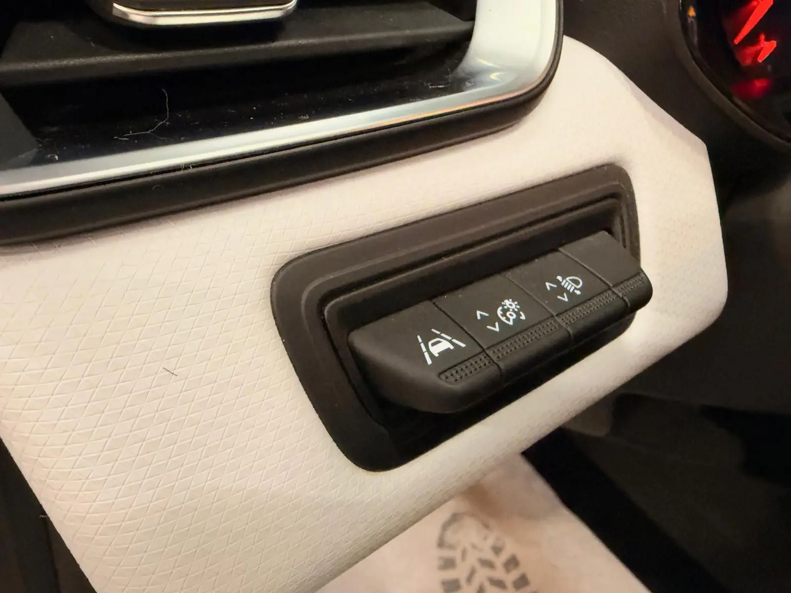 Gros plan sur les commandes d’aide à la conduite sur tableau de bord blanc de la Renault Clio V blanche, version GPL/essence.