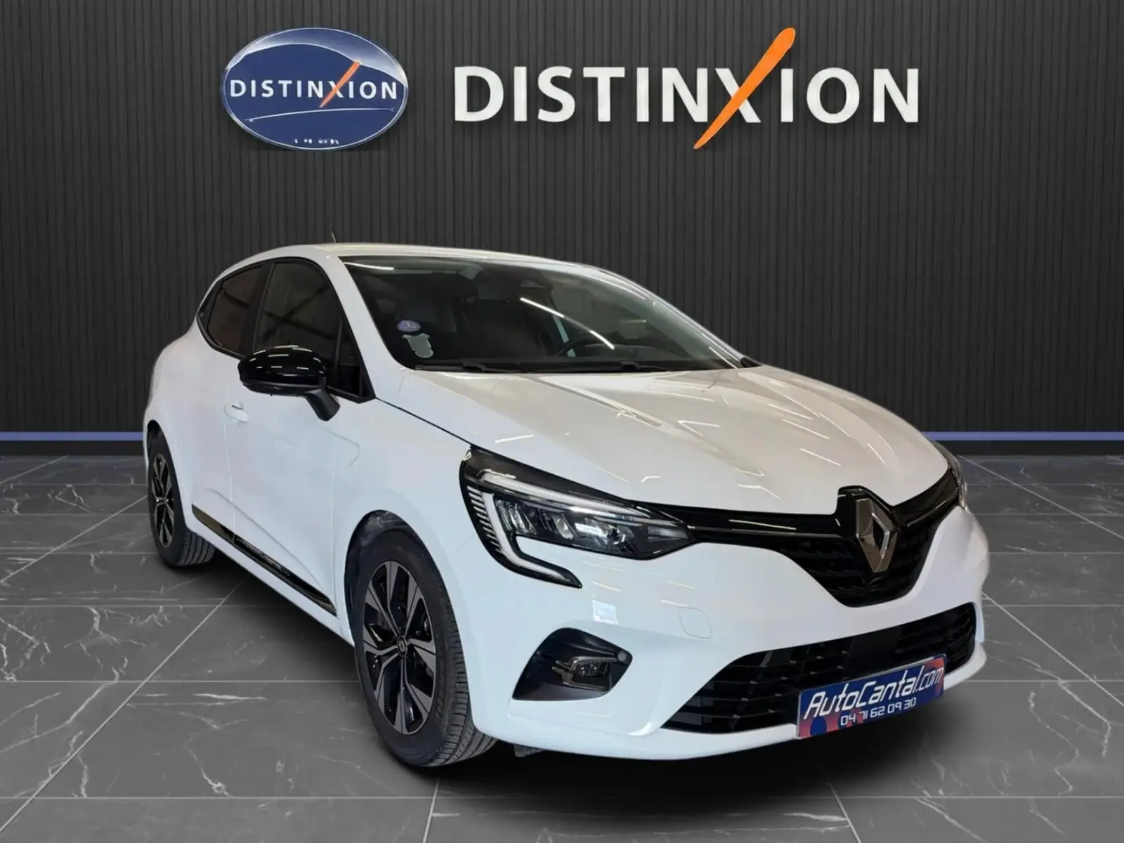 Renault Clio V blanche vue 3/4 avant droit, avec jantes noires bicolores et détails noirs contrastants.